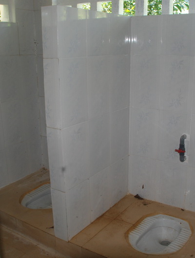 Bệ ngồi tiểu phòng vệ sinh nữ sinh trống trơn, không cửa