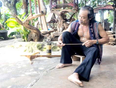 Ông Điểu Chung vót tên cho chiếc nỏ mới làm.