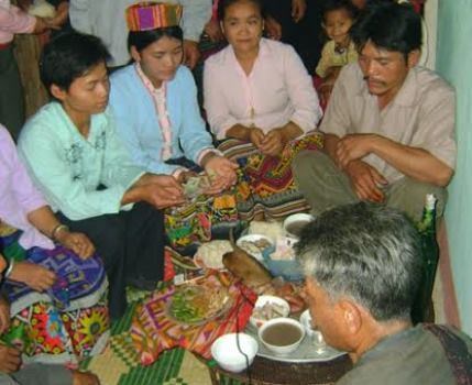 Người Ơ Đu đang xem chân gà ngày tết Chăm Phtrong tại nhà cộng đồng (ảnh CT).