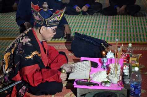 Một thầy Tào đang khấn lễ bằng chữ Nôm Tày.