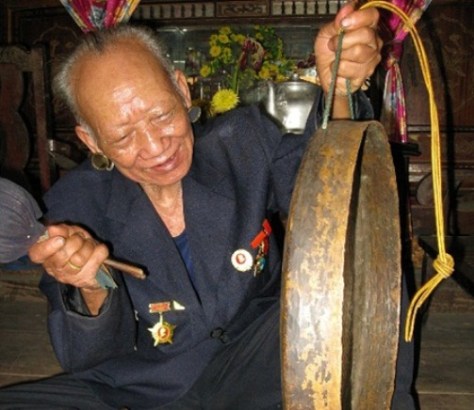 Già làng Kê Xâr, tộc Tà Ôi,  đánh chiếc chiêng đồng.