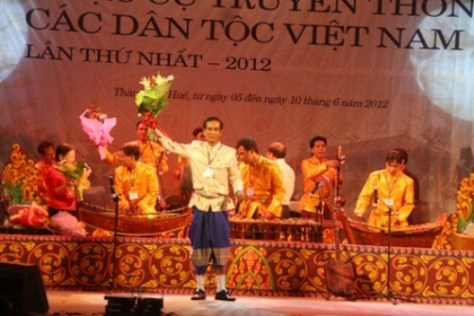 Nghệ sĩ Lý Hùng - quyền đội trưởng đội thông tin văn nghệ Khmer Bạc Liêu nhận hoa chúc mừng từ ban tổ chức. Sự có mặt của đội đã thổi một luồng không khí tươi mới của miền Nam vào liên hoan.