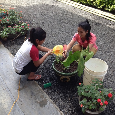 1/ Ảnh em Pie và em Việc học sinh lớp 11 chuẩn bị chậu cảnh trang trí phòng cơm cho ngày Tất niên nhà Lưu trú sắc tộc Buôn Hằng.