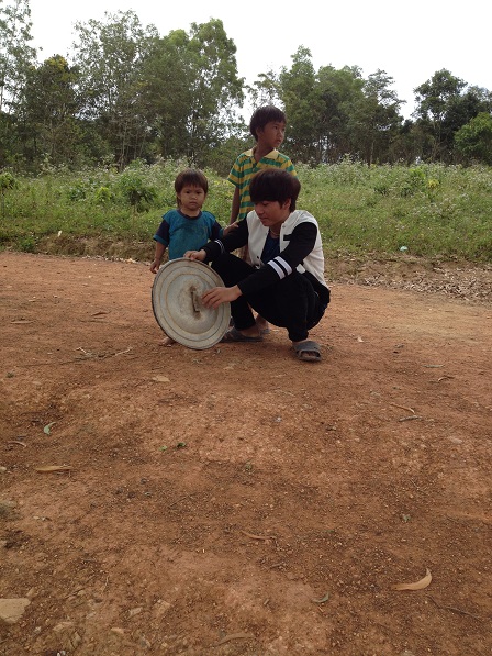 Ảnh ba người con của bố mẹ Thiếu lấy nắp xoong gõ làm tiếng cồng chiêng để chơi.