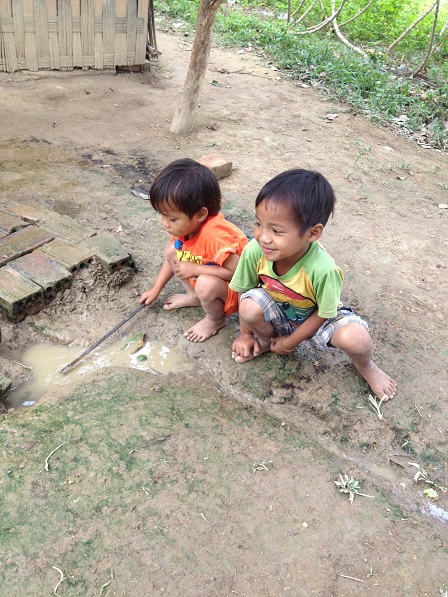 2/ Anh em Thao đã cột xong dây vào cây que và vui vẻ khuấy vũng nước bùn lên chơi với em Win.