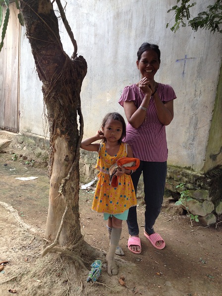 Ảnh mẹ Xi và người con gái út đứng dưới gốc cây trước nhà bên xóm Đào, vui vì Yăh đến thăm.