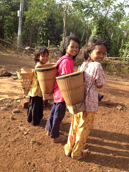 2/ Ảnh sau lưng ba em nhỏ là chiếc gùi đựng những chai nước suối các em lấy về trong khi các em chăn bò.