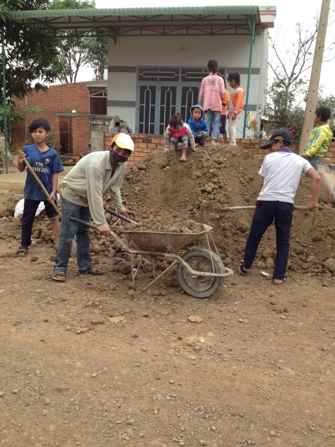 Ảnh những người con của bố mẹ Joang ở thôn Năm, Chúa nhật được nghỉ học giúp bố mẹ Joang chuyển đất đắp nền xây nhà.