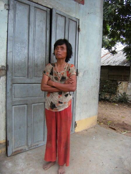 Ảnh cô Lúa bị mù đứng trước cửa nhà của cô ở thôn Hai, căn nhà được xã xây theo chương trình 134.