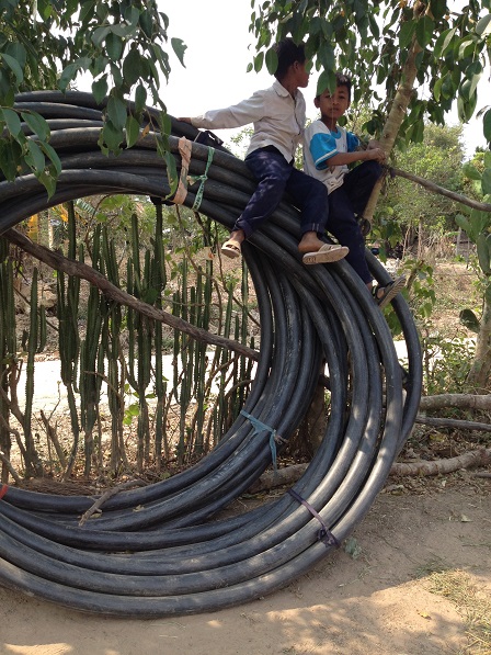 2/ Ảnh hai em Hoal và Xiêm đã trèo lên trên cuộn dây tưới cà-phê và đang ngồi chơi như cưỡi voi.