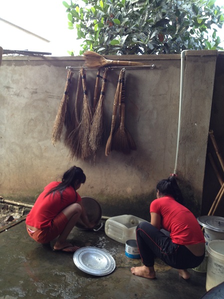 Ảnh em Mỹ Linh (T) và em Mươi (P) đang rửa xoong nhà Lưu trú.