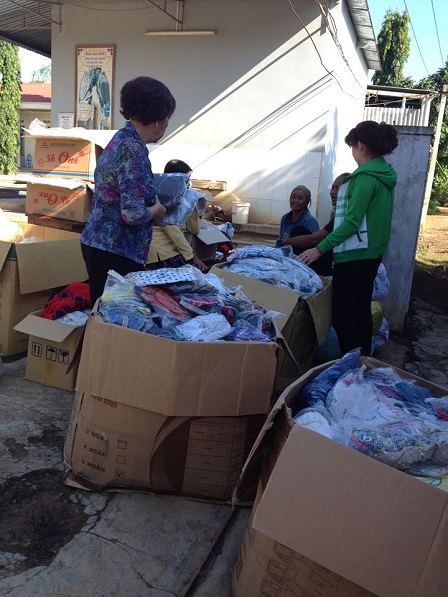 2/ Trước cổng sau của giáo xứ Buôn Hằng, các mẹ thuộc giáo họ Chí Hòa Tp. HCM đang phân chia áo quần mới, để chia sẻ với anh em Buôn Hằng mùa hè 2016.