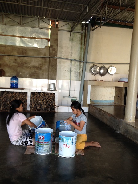 Em Hiểu và em Sal đang sơn các thùng đựng nước trong các phòng tắm nhà Lưu trú.