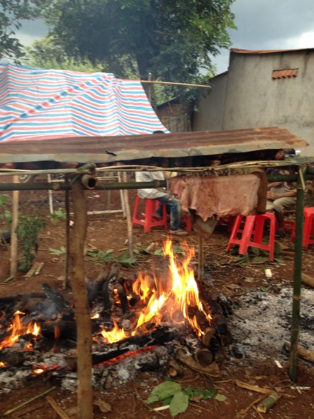 4. Dưới tấm tôn đậy phía trên là thịt bò, và bên hông là miếng da bò, tất cả đang được nướng trong đám tang bà Ú.