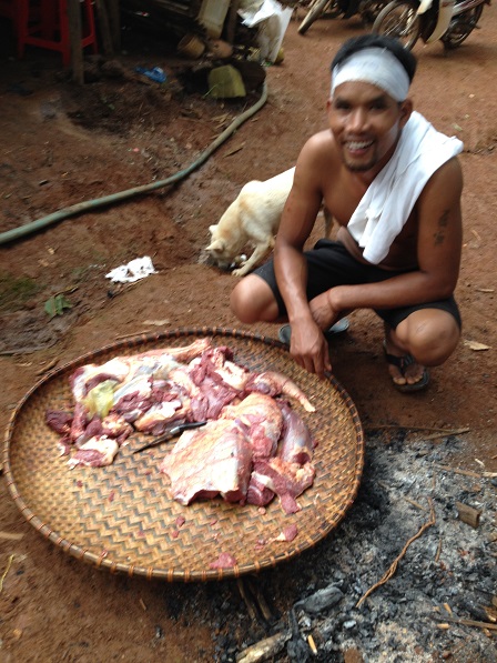 7. Một người cháu của bà Ú ngồi trước nia thịt, trong đám tang bà Ú.