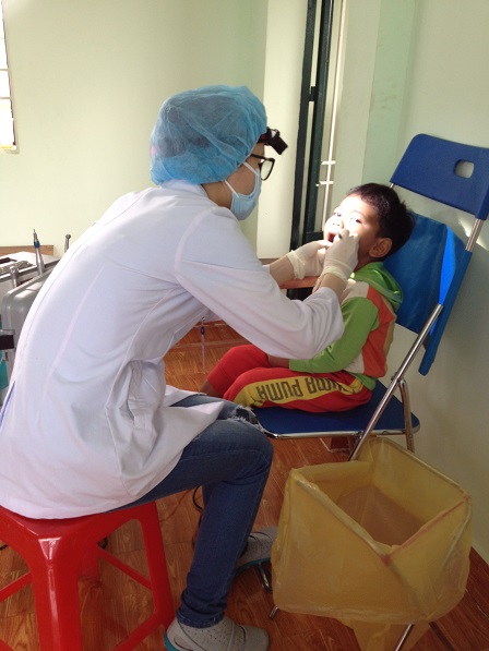 10. Em bé con bố Minh ở Sóc Bù Xiết đang được khám răng