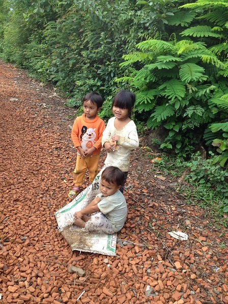 Ảnh ba em nhỏ con bố mẹ Likam lấy bao chơi kéo xe trên con đường bên hông nhà Yah