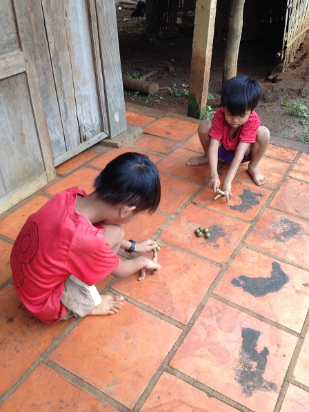 1/ Hai em nhỏ ở sóc Bù Xa chơi bắn bi.